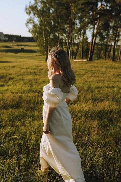 Girl in a white dress dancing in the fields